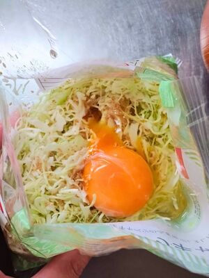 カットキャベツの袋に生卵を落とした様子