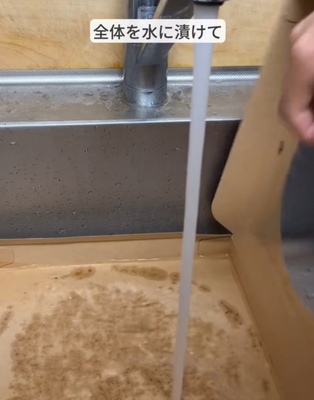 ピザの箱に水をかけている様子