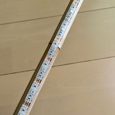 テープライトを丸棒に貼り付ける様子