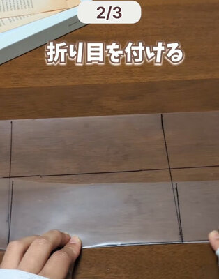クリアファイルに書いた線に沿って折る様子