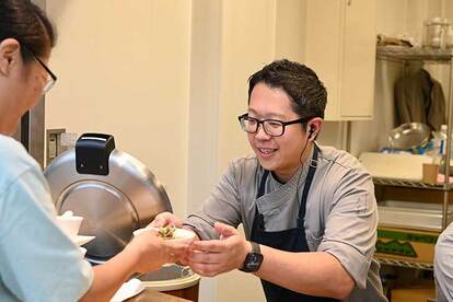 優しい笑みを湛えて配膳する『Restaurant タナカ』の田中シェフ