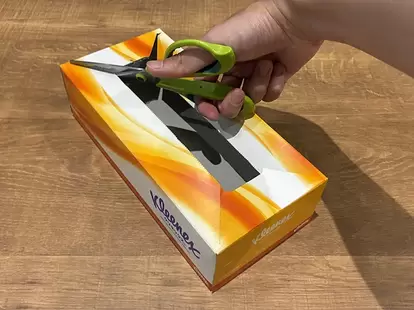 ティッシュの空き箱の隅に切れ込みを入れる場面(撮影:grapeライフハック編集部)