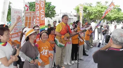 玉城デニー候補の集会の様子。玉城候補は『友よ』(岡林信康)や『スタンド・バイ・ミー』(ベン・E・キング)といった曲を弾き語り