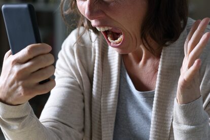 携帯を見て怒る女性