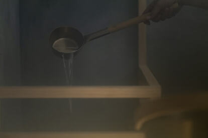 サウナストーンに水をかけて蒸気を発生させる